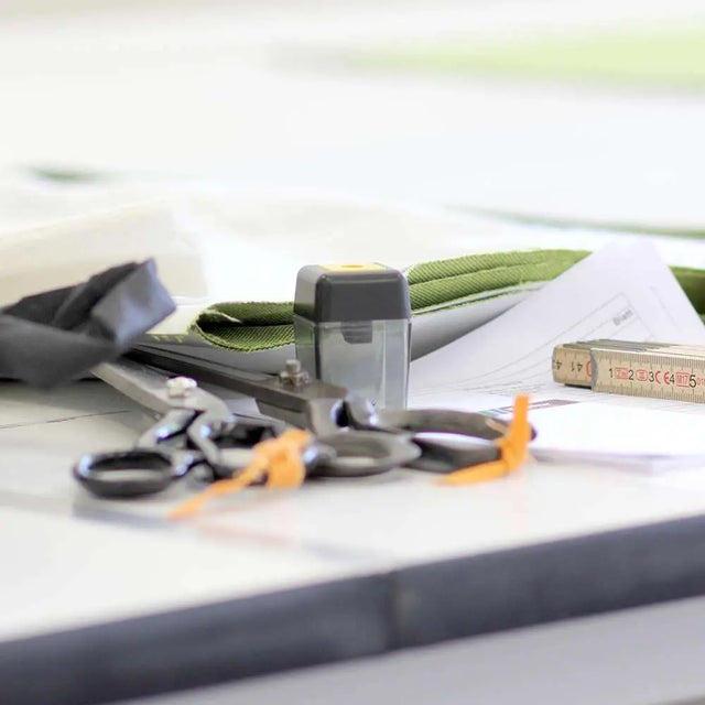 Nähutensilien von BUDDY. Hundezubehör liegen auf einem Nähtisch in einer Werkstatt für Menschen mit Behinderung, die nachhaltige Hundebetten fertigen. Nähutensilien von BUDDY. Hundezubehör liegen auf einem Nähtisch in einer Werkstatt für Menschen mit Behinderung, die nachhaltige Hundebetten fertigen.